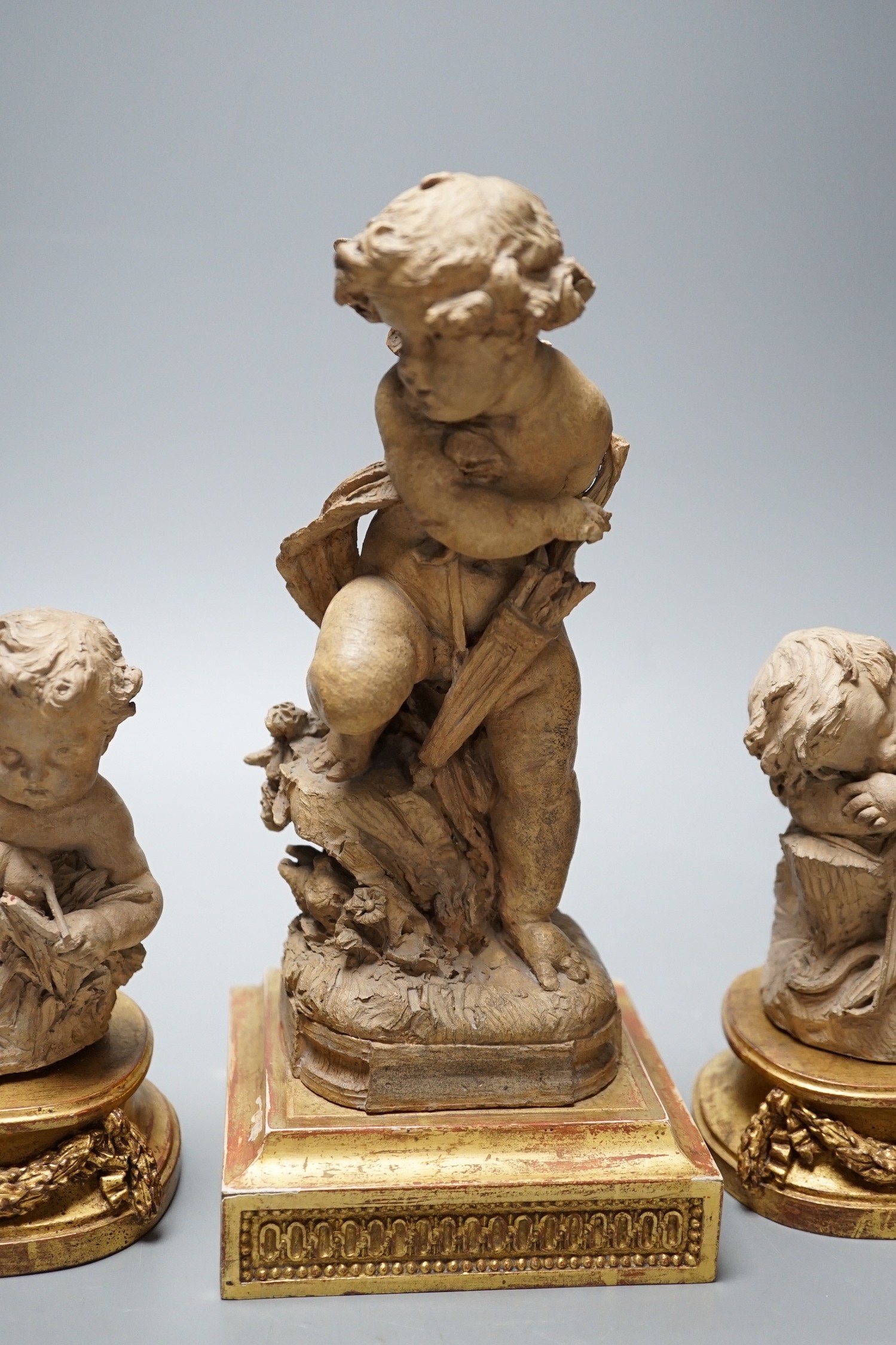 Two 19th century French terracotta cherubs and one other Cupid, after Clodion, all on giltwood stands, tallest 23.5cm